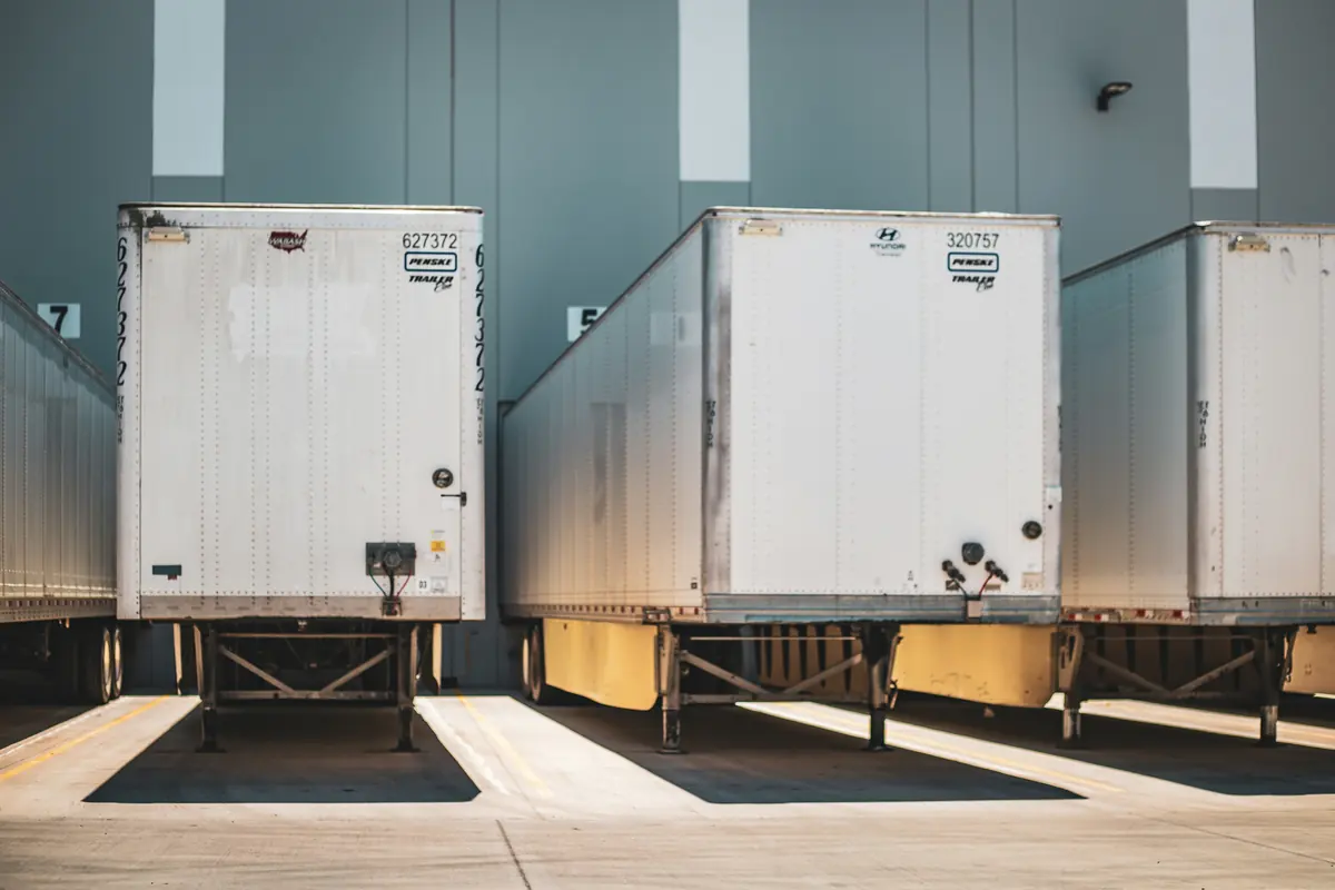 Dry van trailers backed into loading dock doors at a distribution warehouse