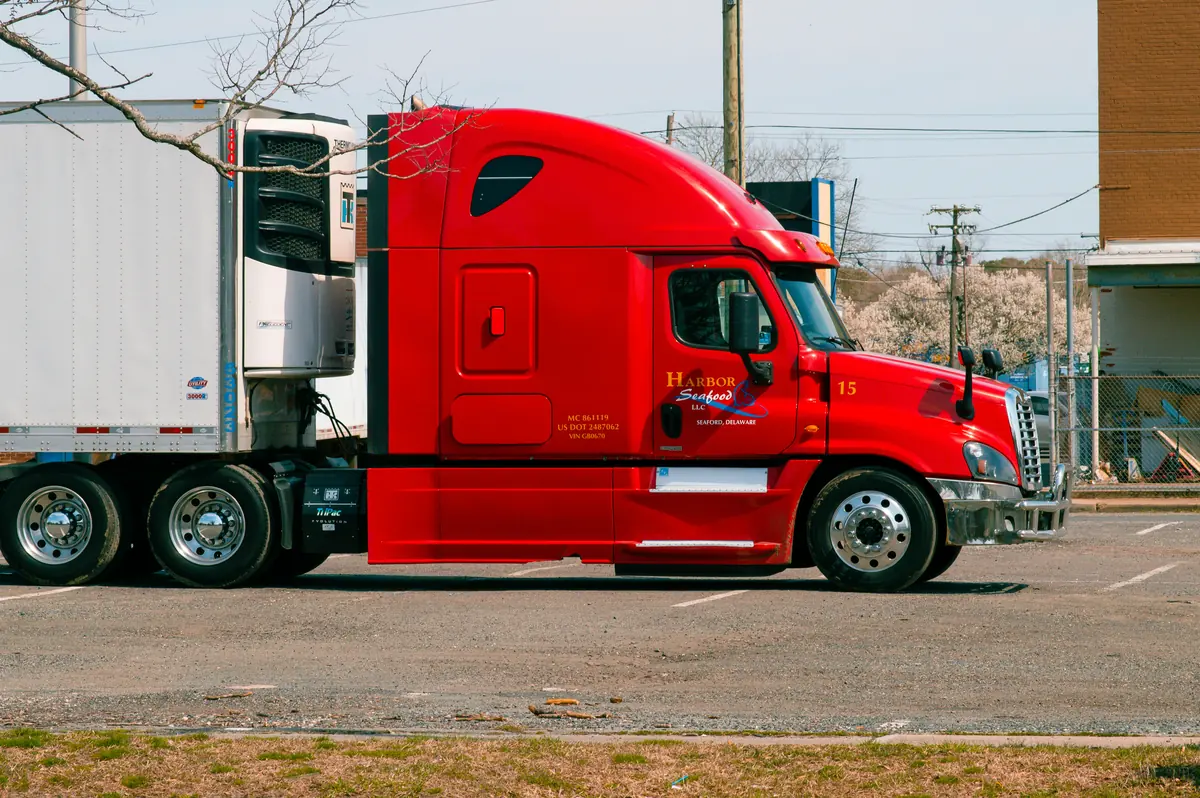 Red Freightliner Cascadia sleeper hooked to a refrigerated trailer